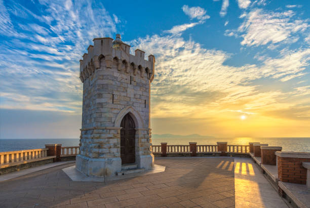 Tramonto sul faro di Piombino da Piazza Bovio, isola d'Elba sullo sfondo